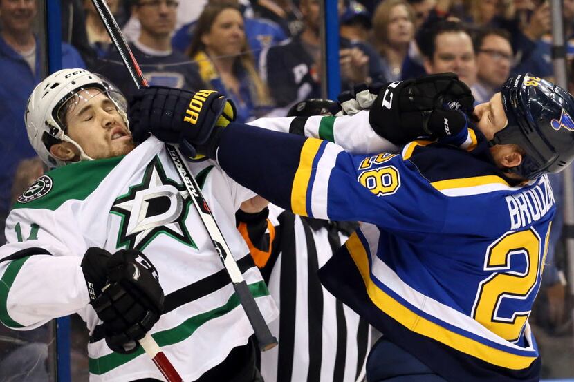 St. Louis Blues center Kyle Brodziak, right, fights with Dallas Stars left wing Curtis...