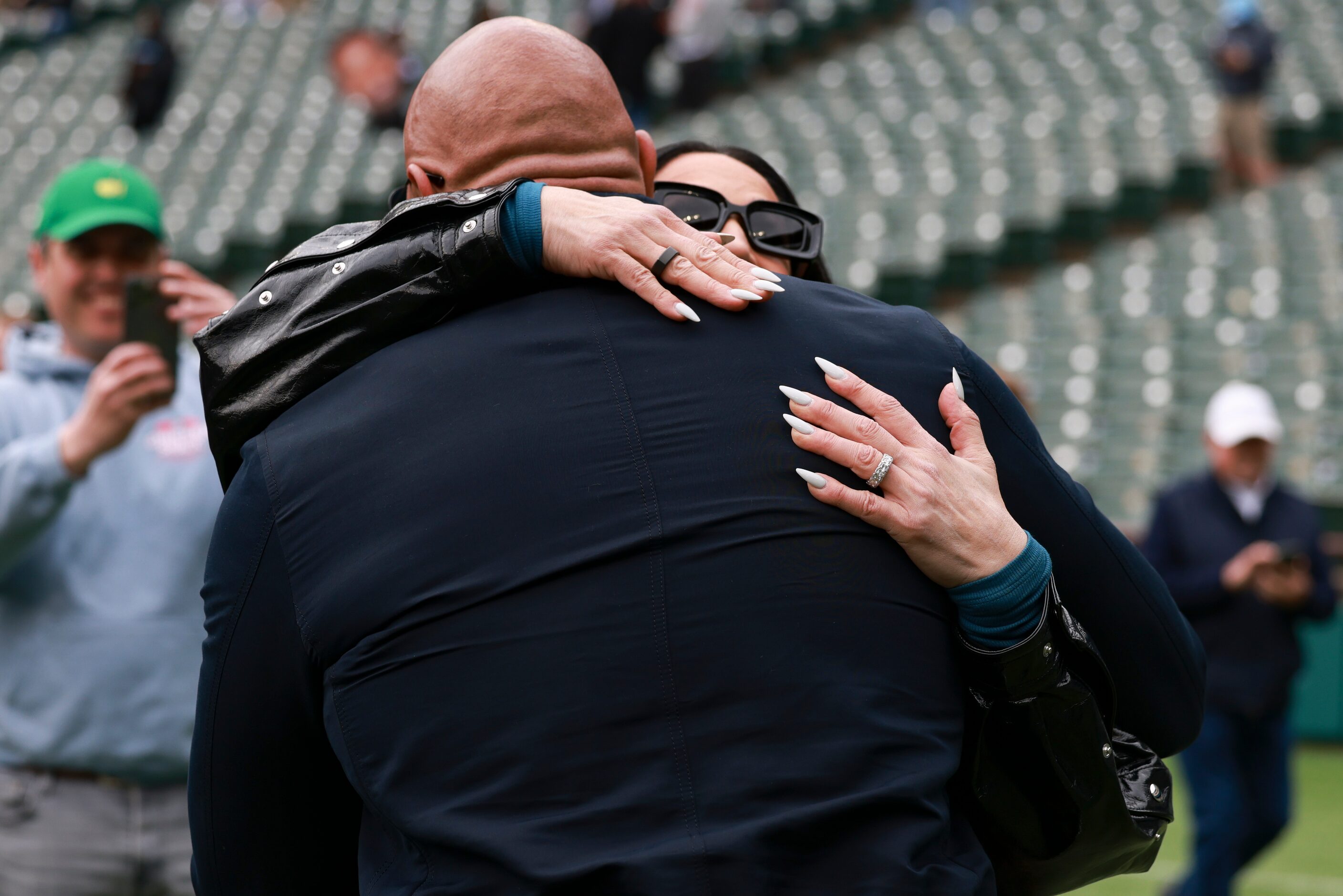 Dany Garcia hugs her husband, Dwayne “The Rock” Johnson, before an XFL football game between...