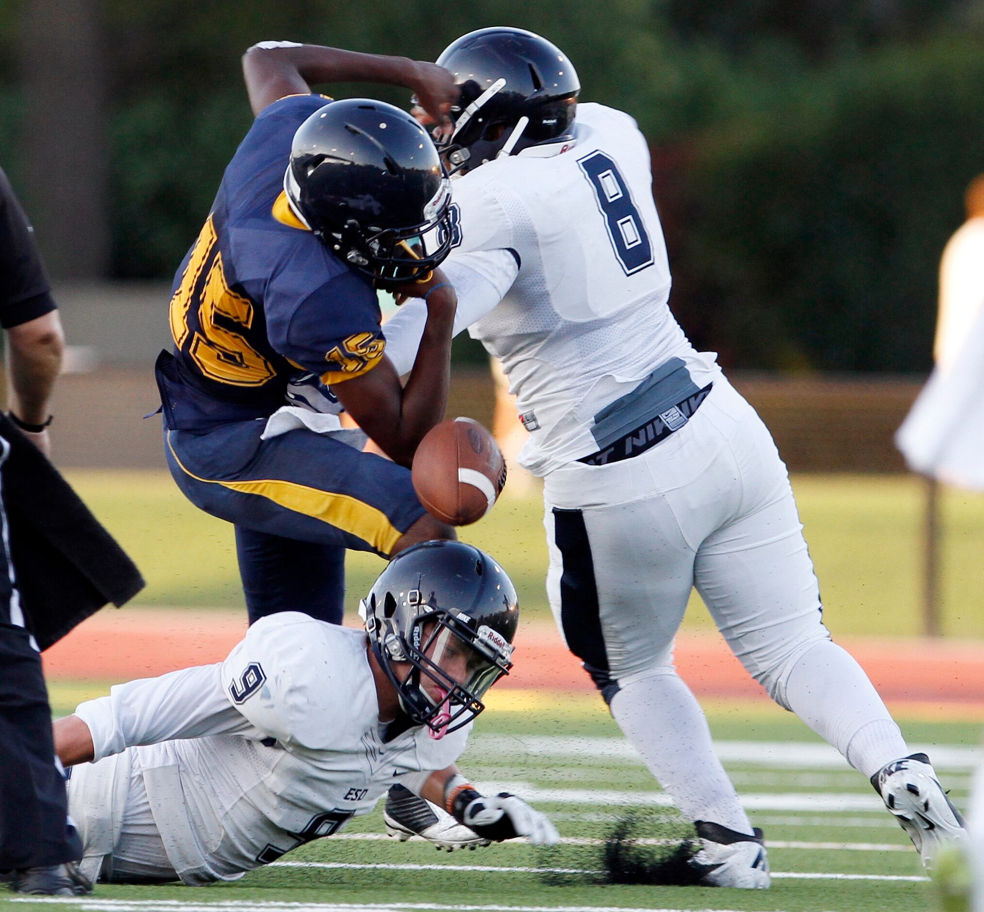 St. Mark's senior quarterback Matthew Placide (15) fumbles the football after being hit by...