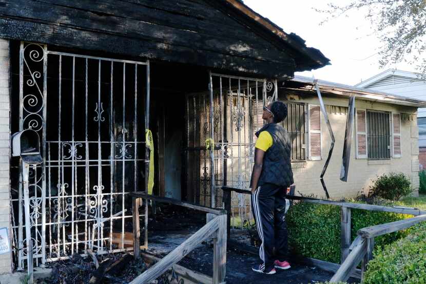 
Ona Marie Hendricks, niece of Johnnye T. Hughes, looks up at her aunt’s charred home in...