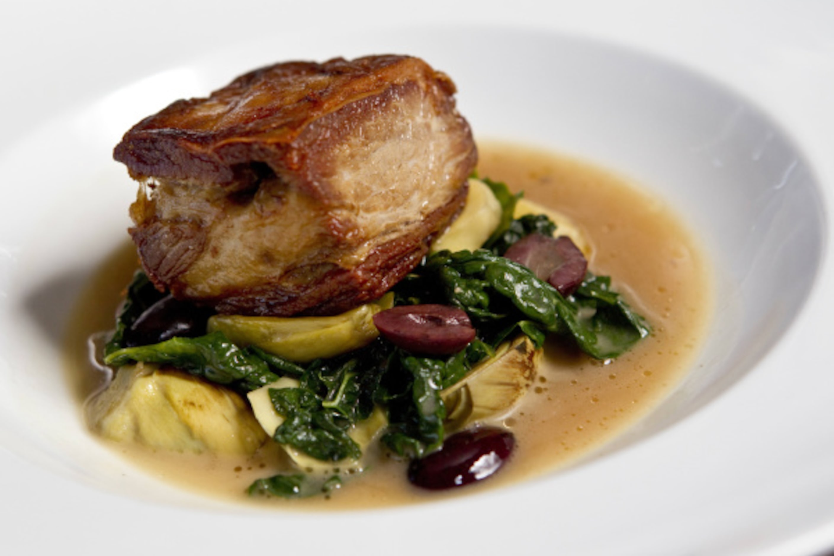 Lamb breast, braised and surrounded by baby artichokes, Kalamata olives and kale, at Bolsa...