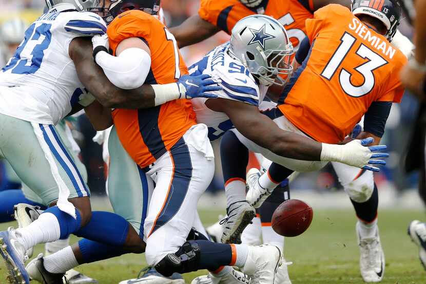 Dallas Cowboys defensive end Demarcus Lawrence (90) forces a fumble as he sacks Denver...