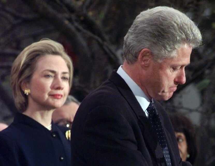 First lady Hillary Rodham Clinton watches President Clinton pause as he thanks those...