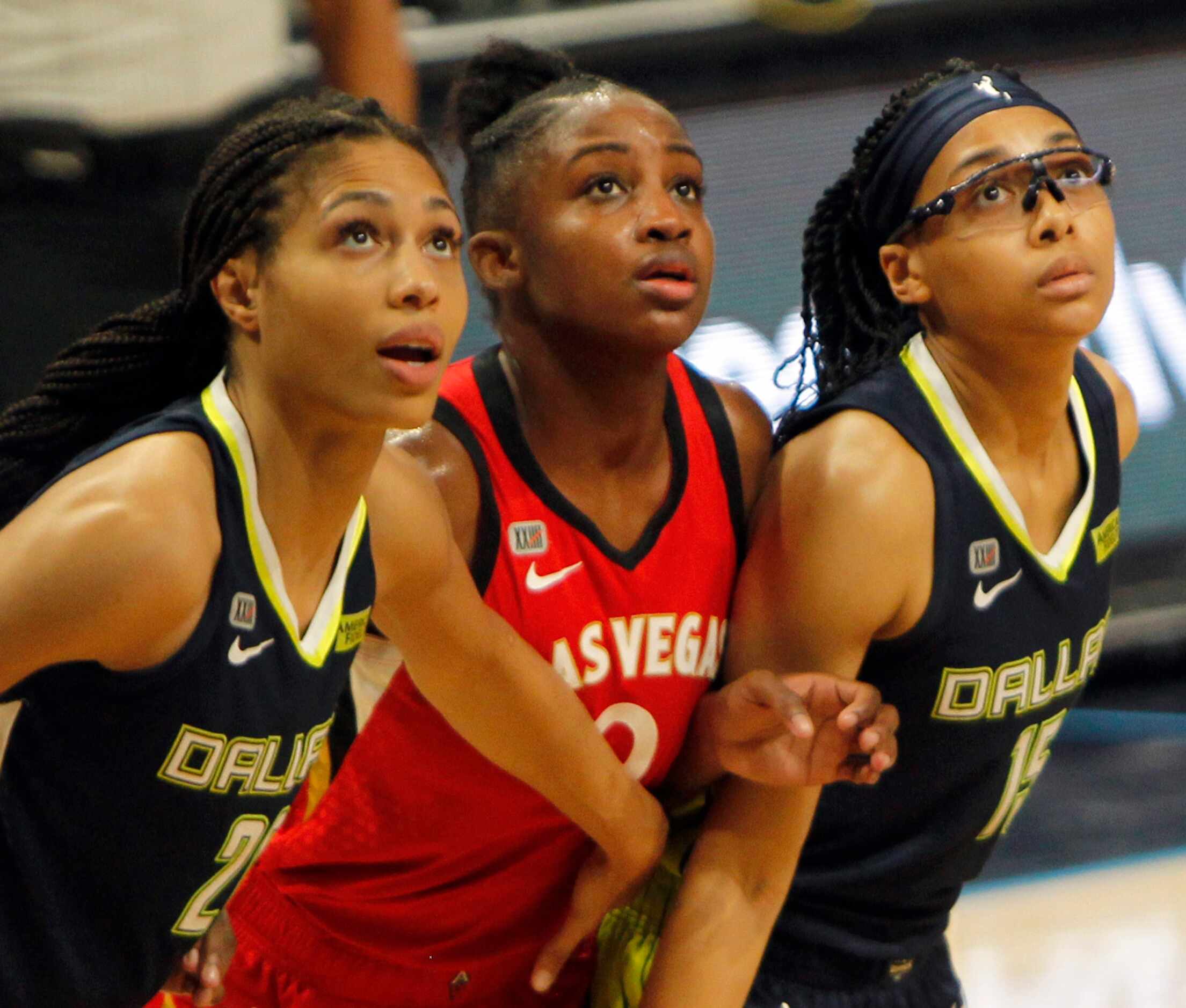 Las Vegas guard Jackie Young (0), center, is framed by Dallas Wings forward Isabelle...