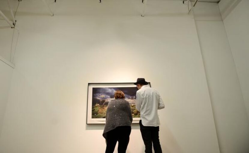 
Diana Pollak and Jason Acton look at a photograph by Shawn Saumell at the Cohn Drennan...