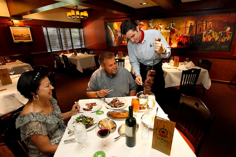 Norma (left) and Jerry Bishop of Heath, are served by Daniel Santana (right) in the dining...