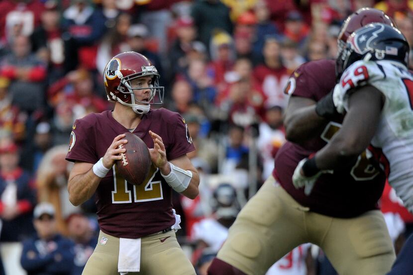 Washington Redskins quarterback Colt McCoy (left) drops back to pass during an NFL football...
