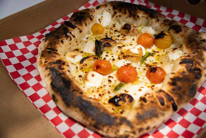 Desmon Coleman, owner of Hustle Town Pizza, prepares a springtime vegetable pizza at Hop and...