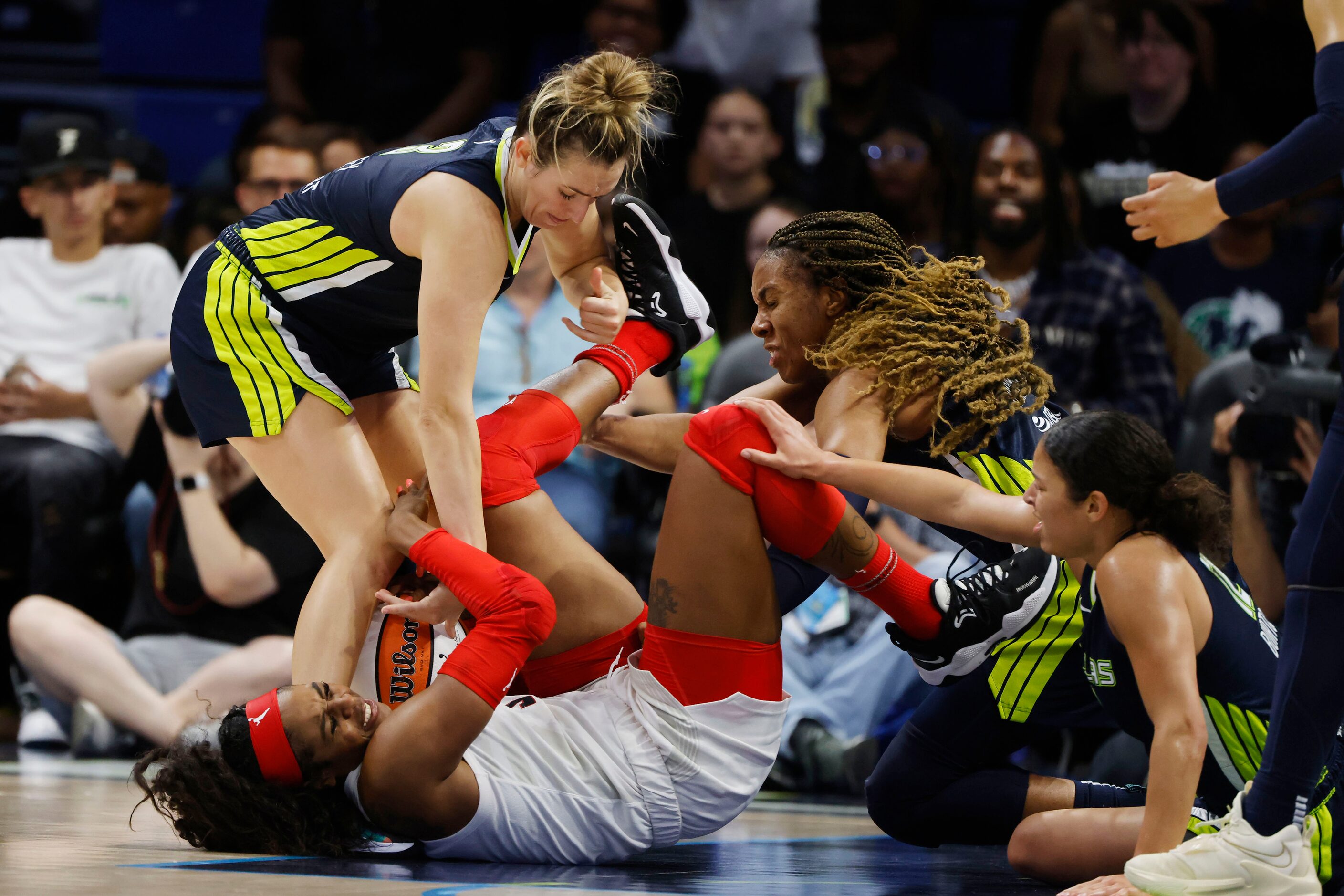 Atlanta Dream forward Cheyenne Parker (32), bottom, kicks Dallas Wings forward Kayla...