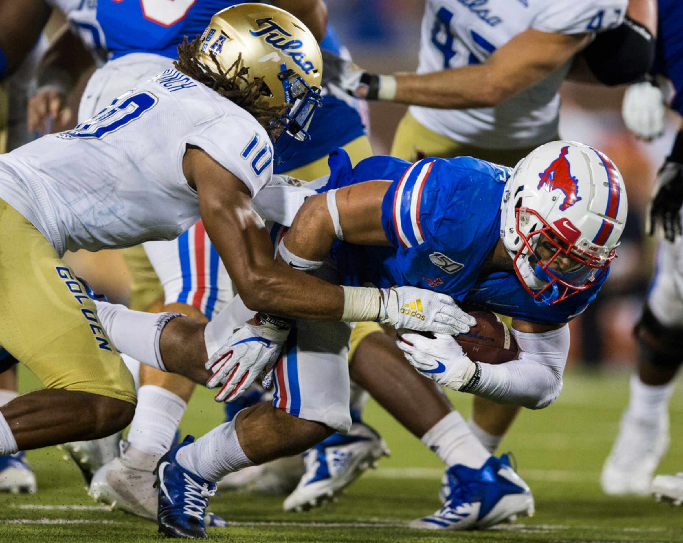 SMU Mustangs running back Xavier Jones (5) has the ball knocked out of his hands by Tulsa...