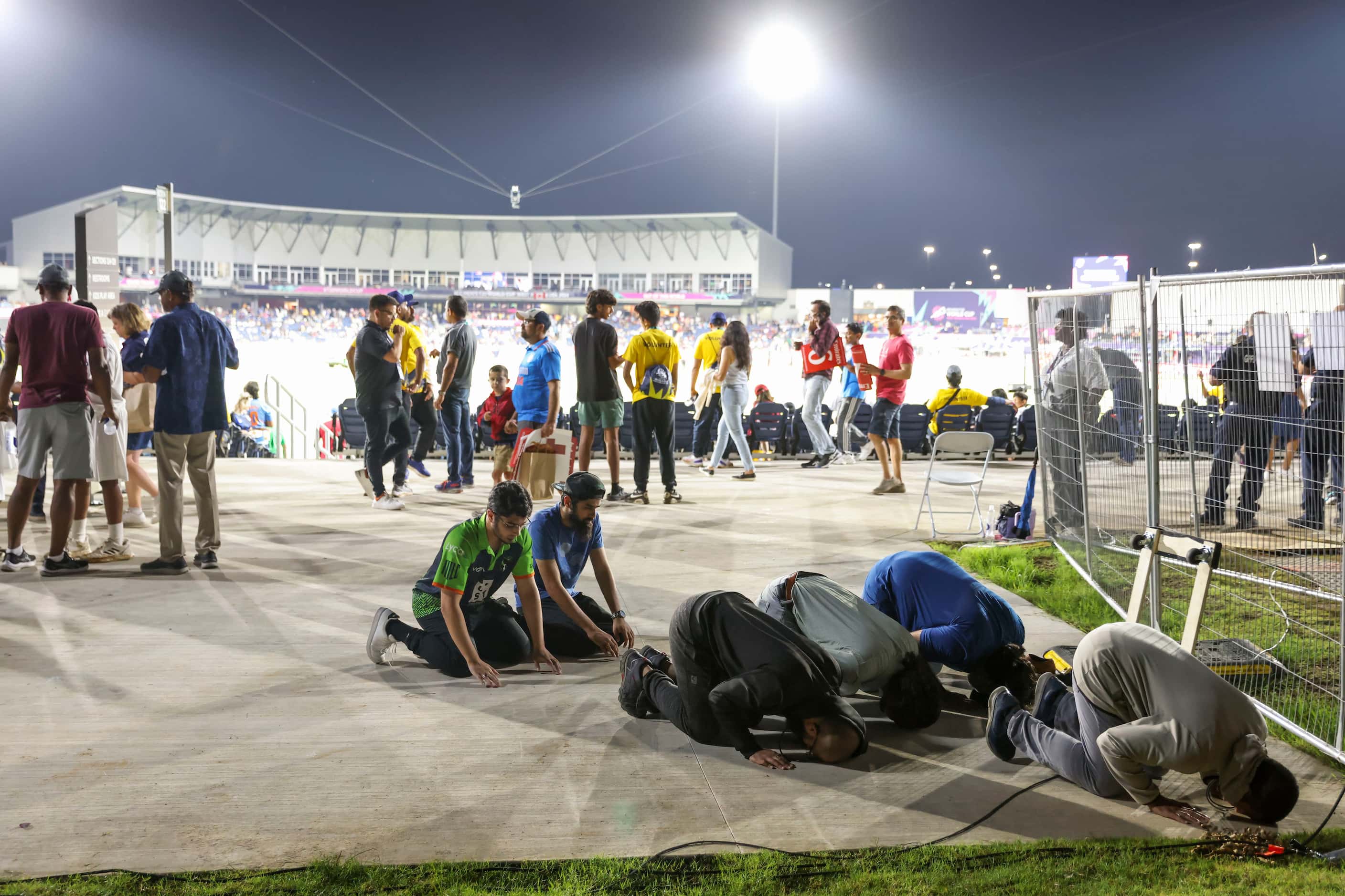 Muslims pray Isha, as other go around the concourse during the men's T20 World Cup cricket...