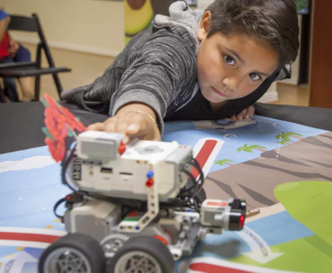 
				Haaron VIdaña, de 8 años, juega con un auto robótico durante la presentación de un...