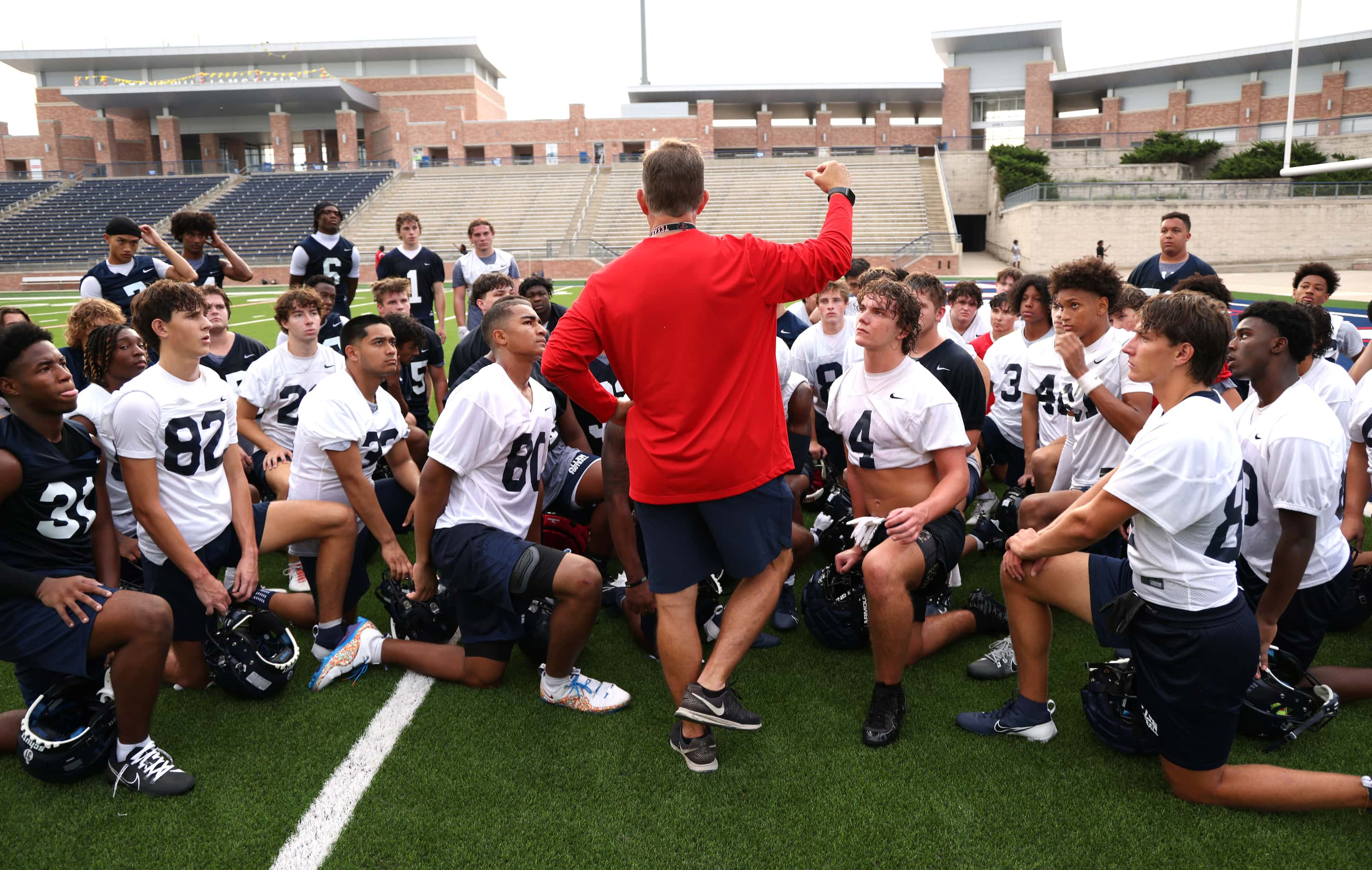 Allen head coach Lee Wiginton speaks to a focused group of players as he shares feedback...