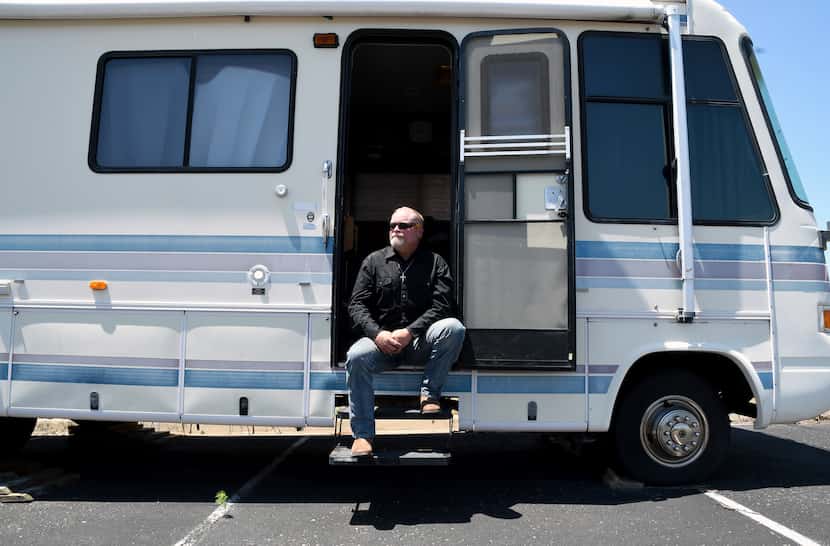 Joe Ridenour sits for a portrait on the steps of the recreational vehicle he once called...