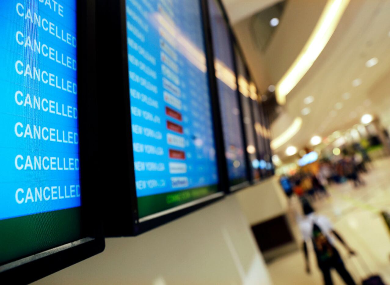 A departure board displays flight cancellations to Miami at Hartsfield-Jackson Atlanta...