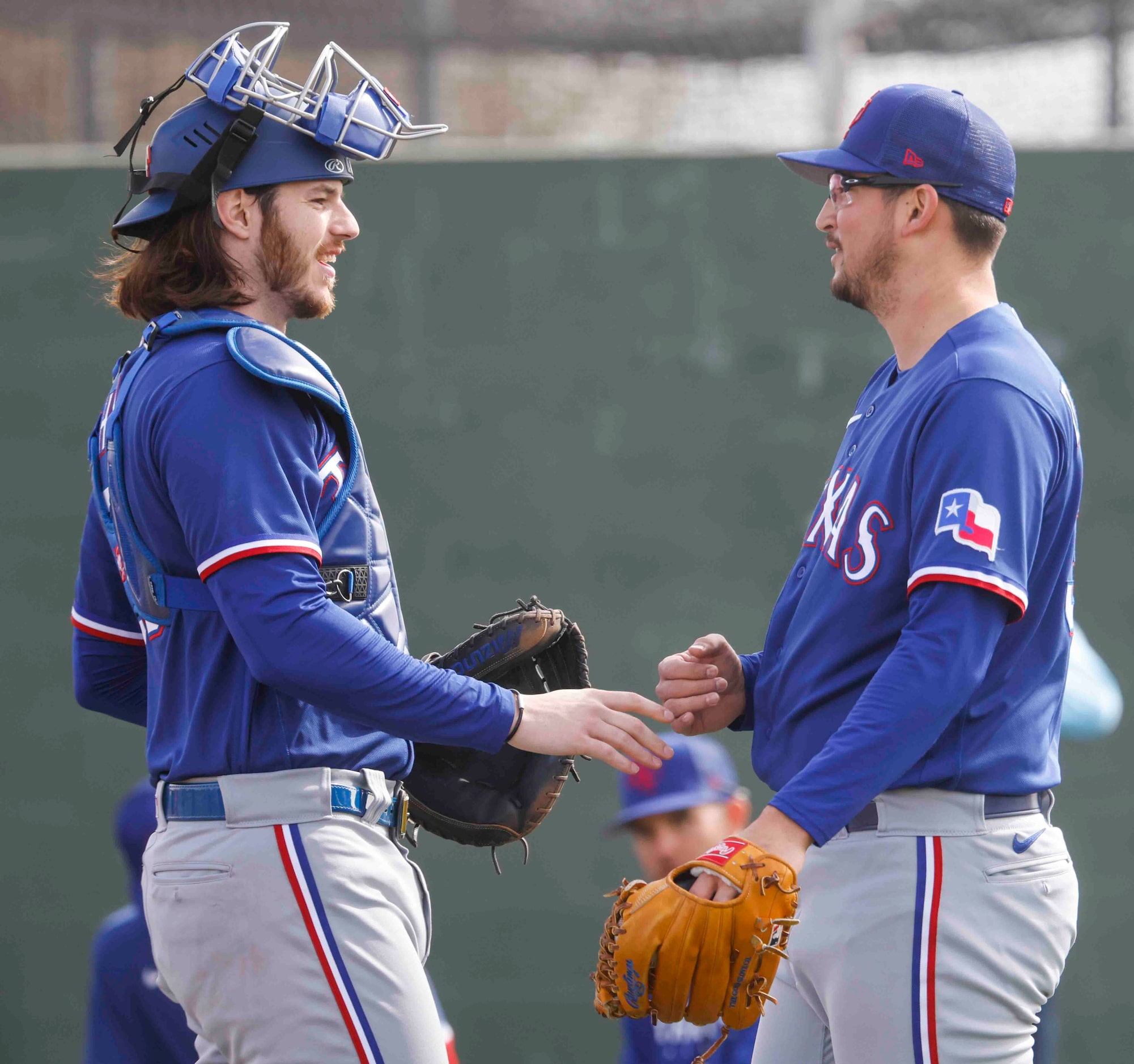 Texas Rangers catcher Jonah Heim, left, talks to pitcher Dane Dunning during a spring...