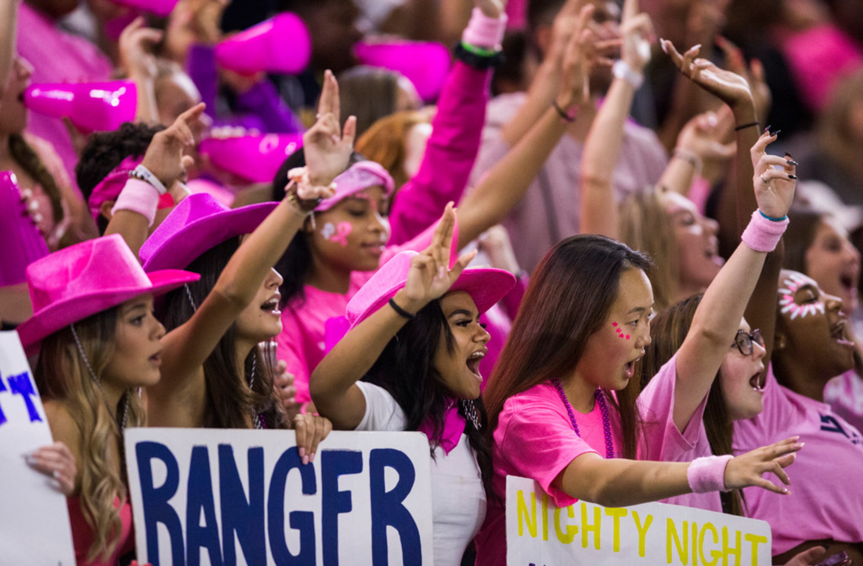 Frisco Lone Star fans wearing pink for Breast Cancer Awareness Month cheer after a touchdown...