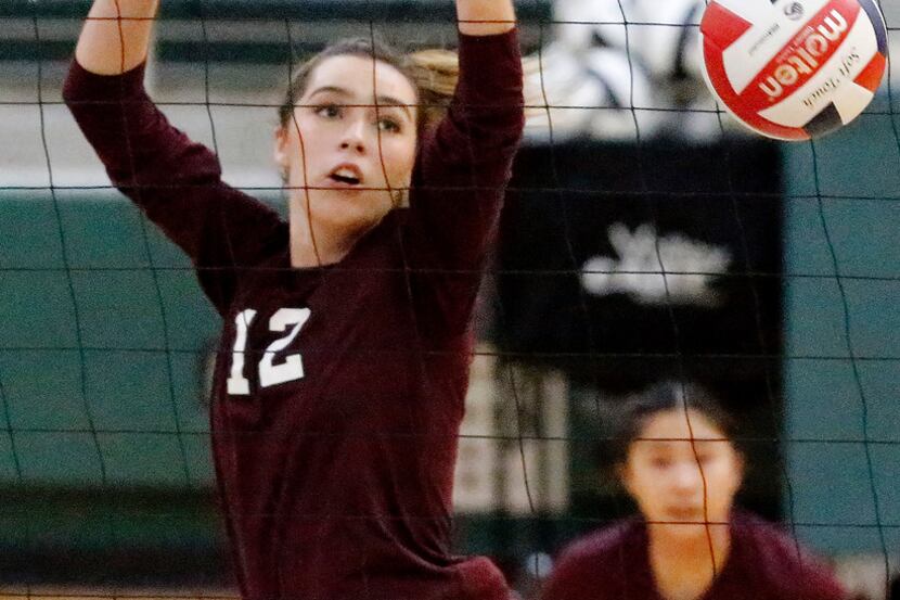 Plano outside hitter Julia Adams (12) gets a block in a match earlier this season against...