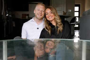 Cody and Taylor Martin sit in front of the coffee table that brought them together on...