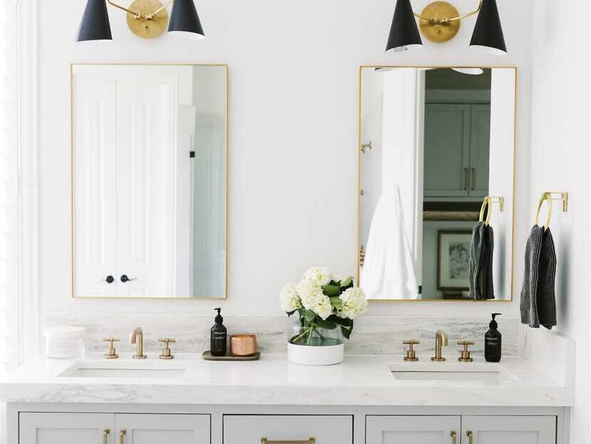 A bathroom vanity features two gold mirrors.