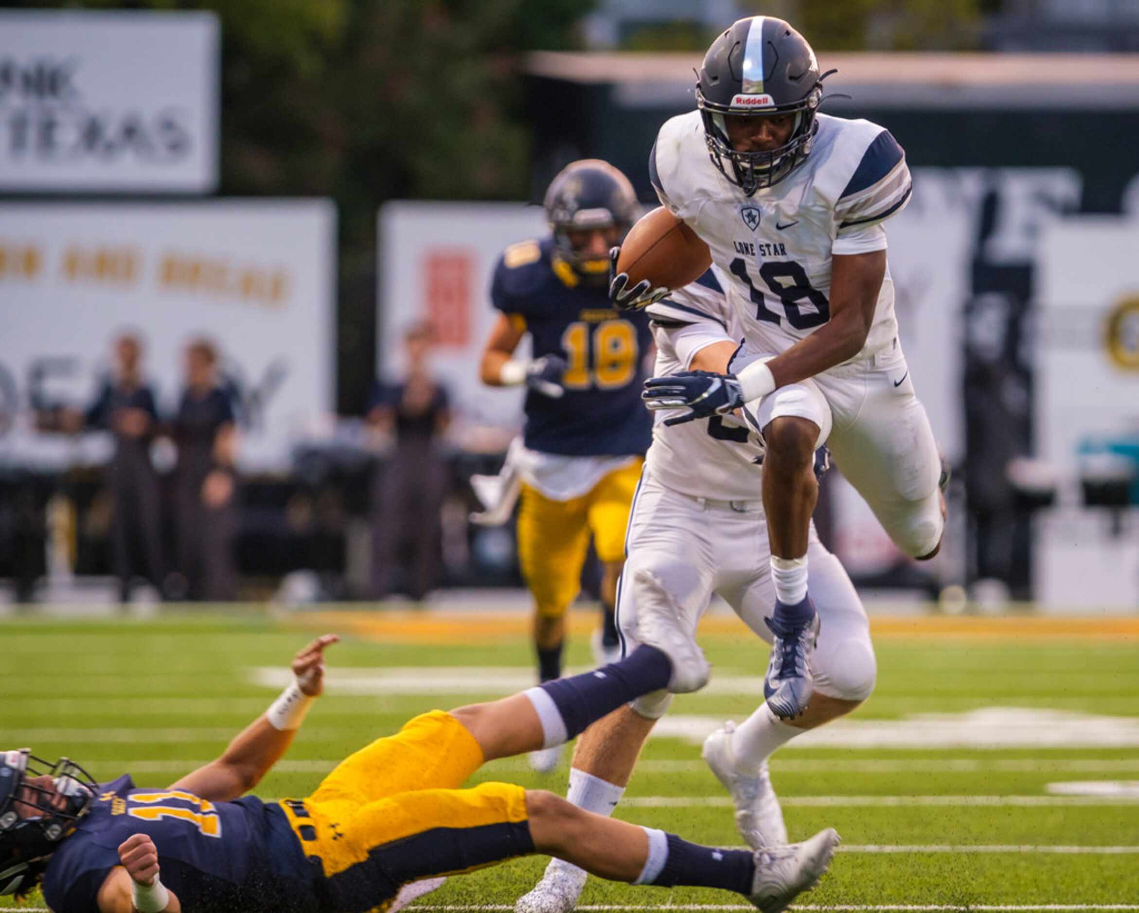 Frisco Lone Star wide receiver Marvin Mims (18) hurdles Highland Park kicker Hayden Clyce...