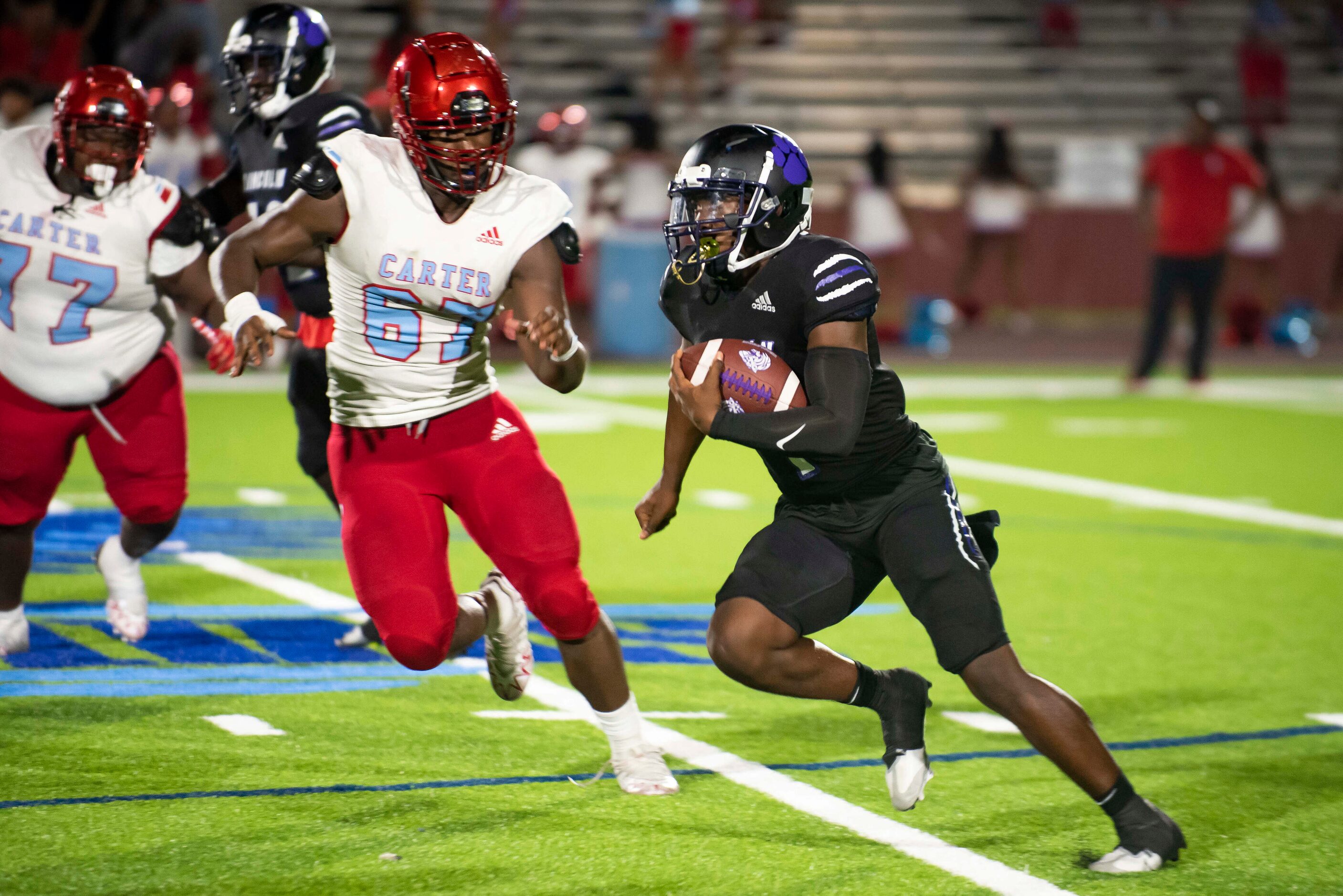 Lincoln senior Jaden Cole (1) runs past Carter senior Stephen Brock (67) to gain yardage...