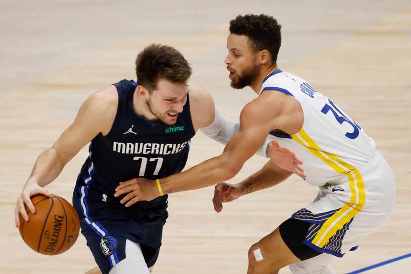 Dallas Mavericks guard Luka Doncic (77) drives on Golden State Warriors guard Stephen Curry...