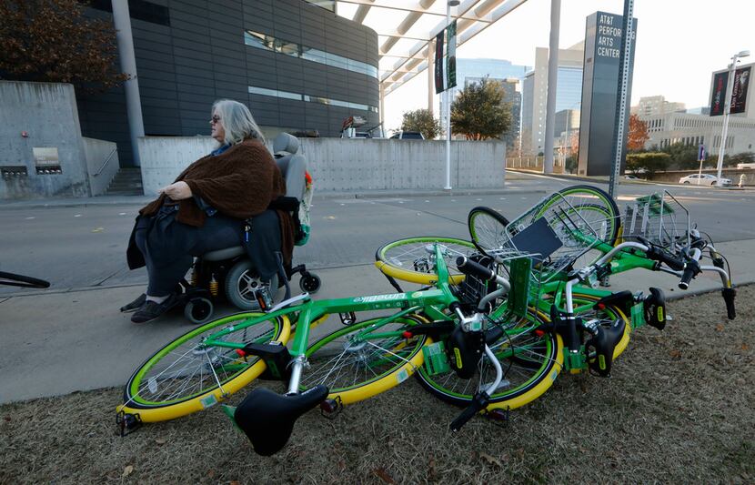 Melody Townsel  maneuvers her wheelchair past knocked-over rental bikes near the school in...
