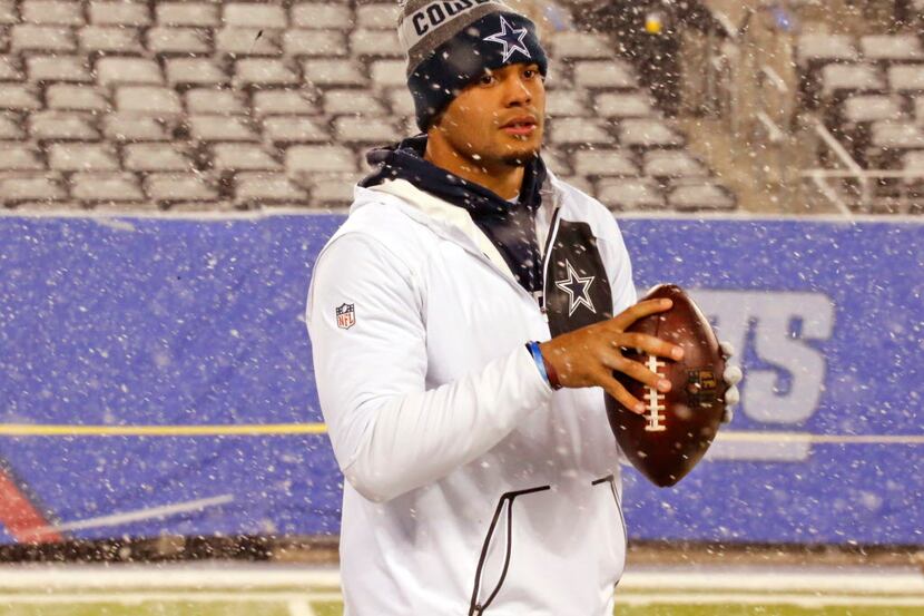 Dallas Cowboys quarterback Dak Prescott warms up in the snow during early pre-game warmups...