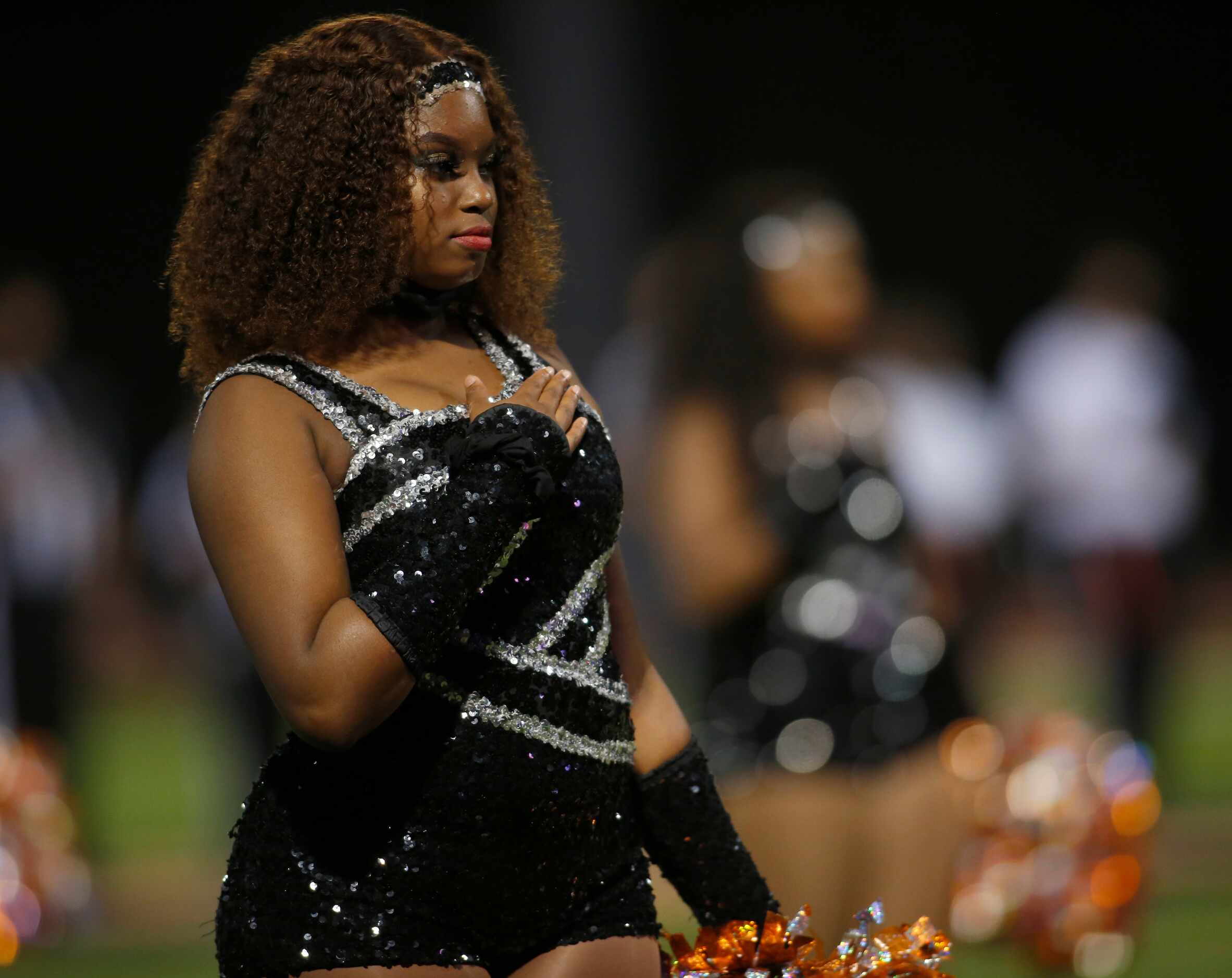 A member of the Lancaster Tigers drill team pauses for the playing of the national anthem...