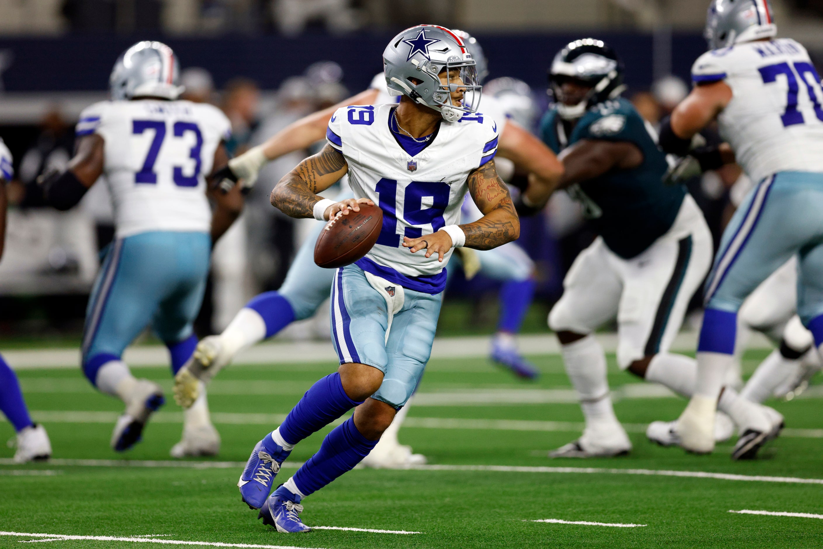 Dallas Cowboys quarterback Trey Lance (19) scrambles out of the pocket as he looks to throw...