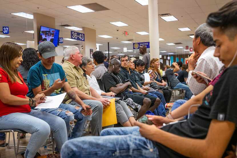 People wait inside a "mega center" run by the Department of Public Safety in Garland, Texas ...