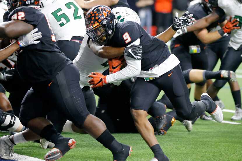 Aledo's Jase McClellan (9) is tackled by Mesquite Poteet's Noah Ingram (44) on the way to...