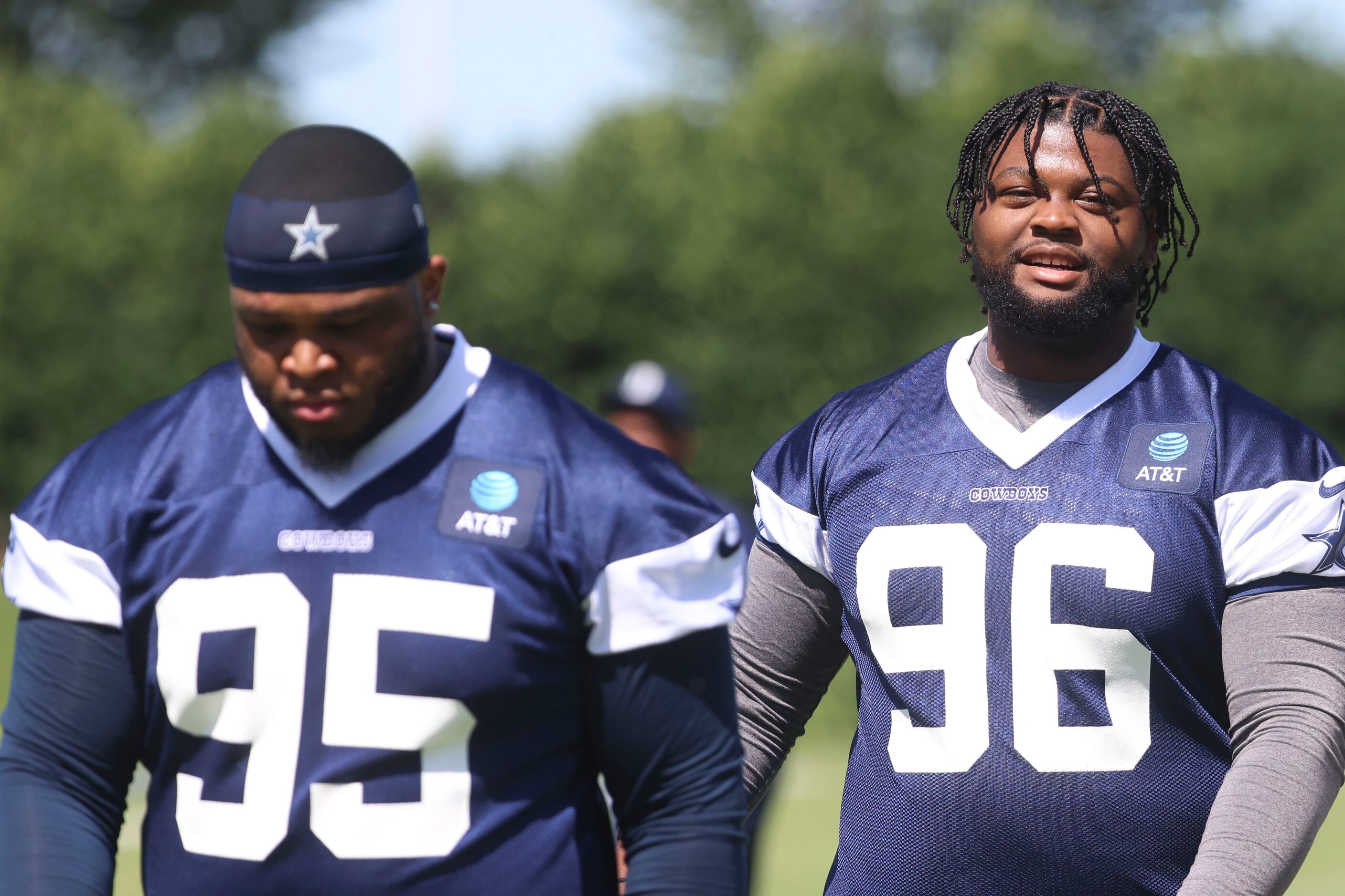 Dallas Cowboys defensive tackle Denzel Daxon (95) and Justin Rogers (96) exit the field...