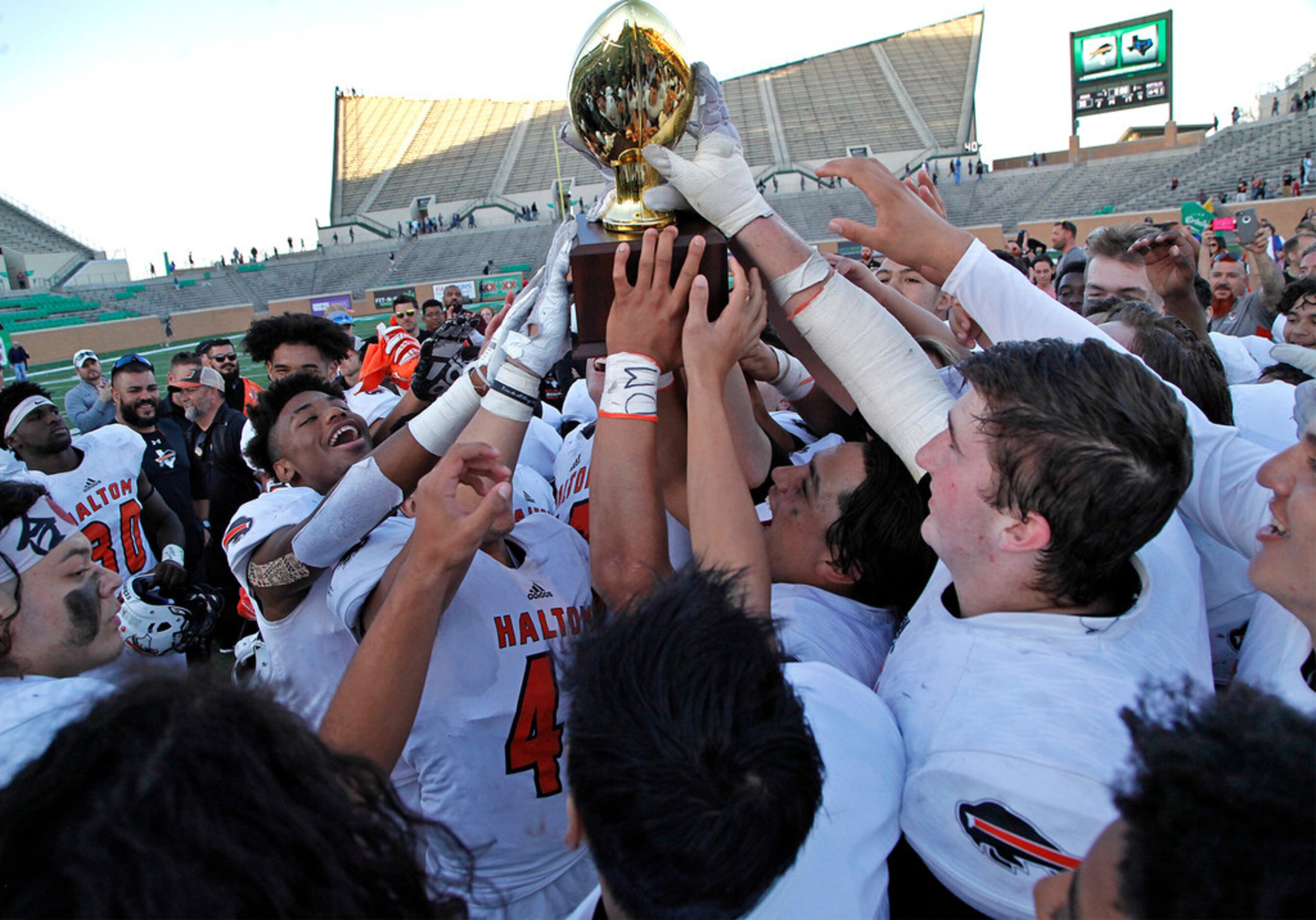 Haltom High School hoists up their trophy after they defeated Hebron High School 41-30 in a...