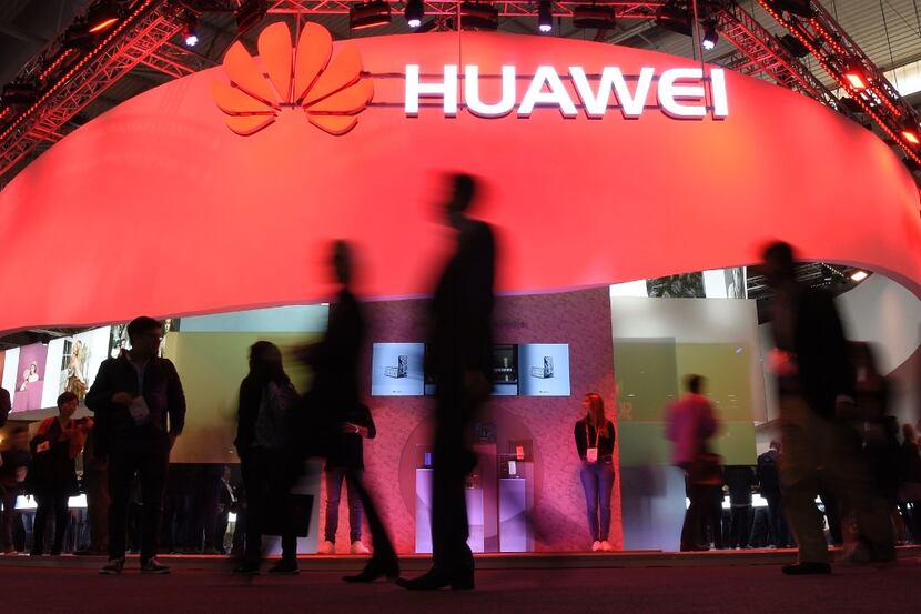 Visitors pass in front of the Huawei's stand on the first day of the Mobile World Congress...
