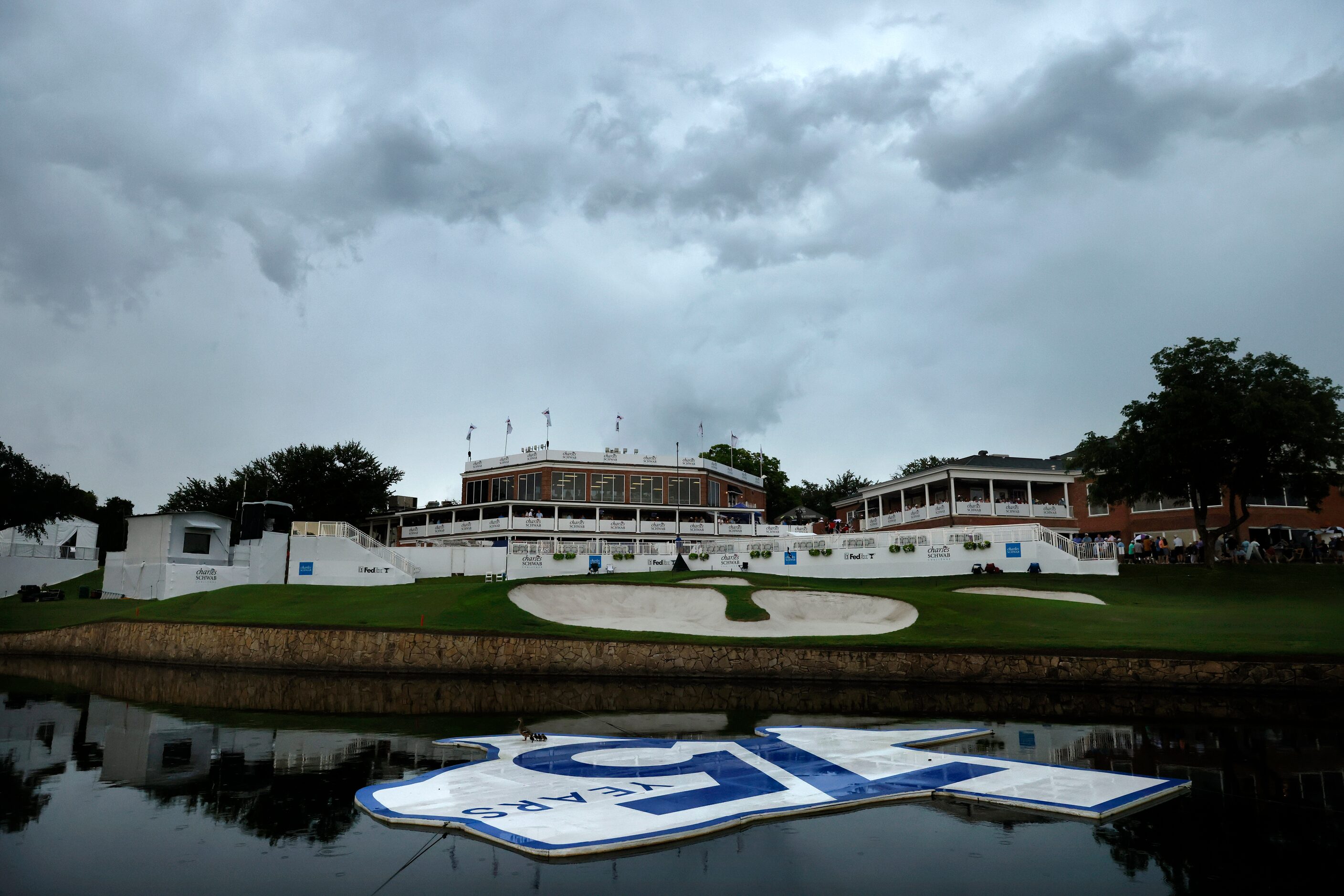 Storm clouds roll over the clubhouse and pond bearing a 75th Anniversary logo after golf was...