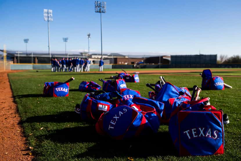Texas Rangers bags and equipment lay on the field during a spring training workout at the...