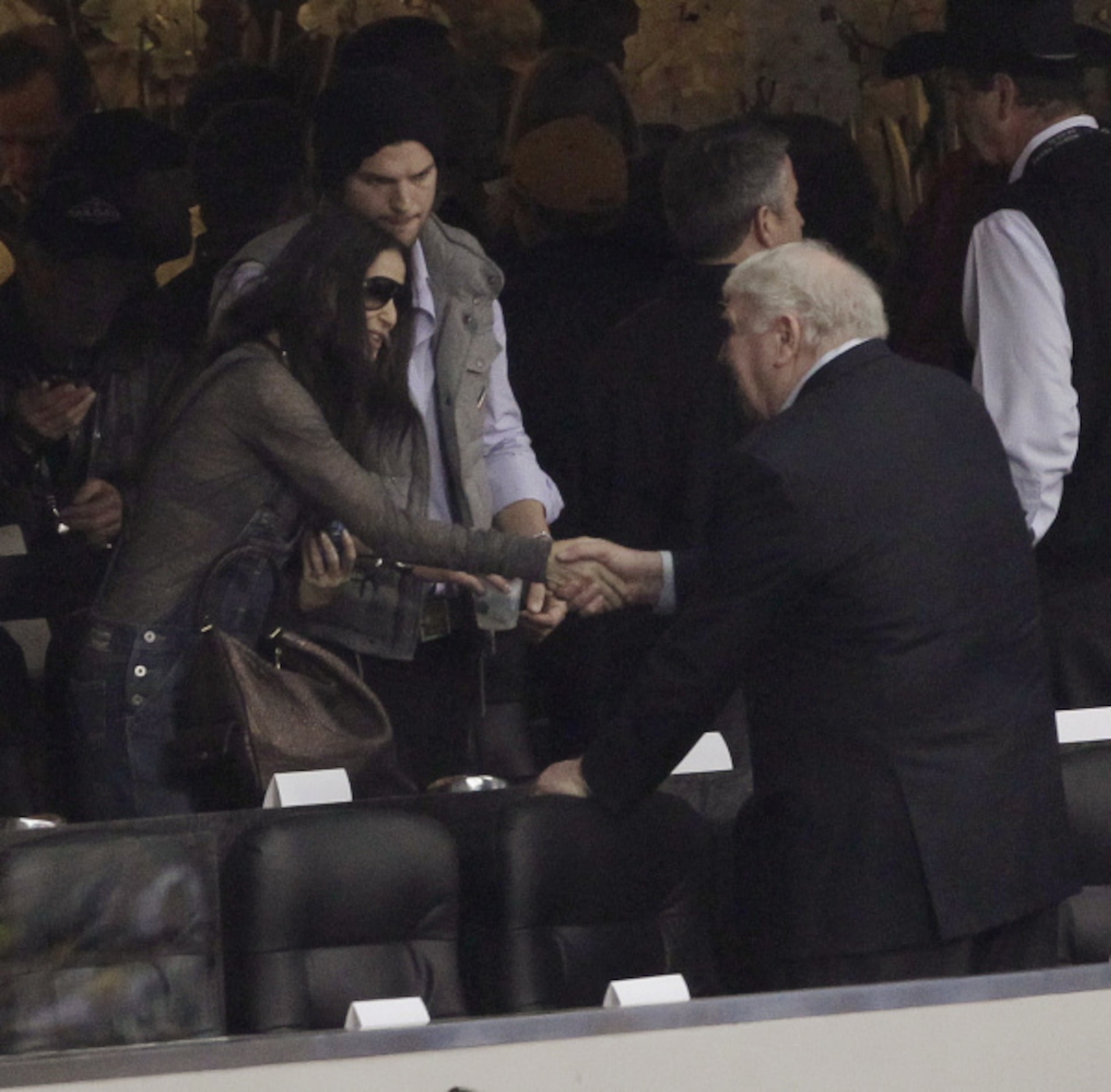 Sports broadcaster John Madden, right, shakes hands with actors Demi Moore and Ashton...