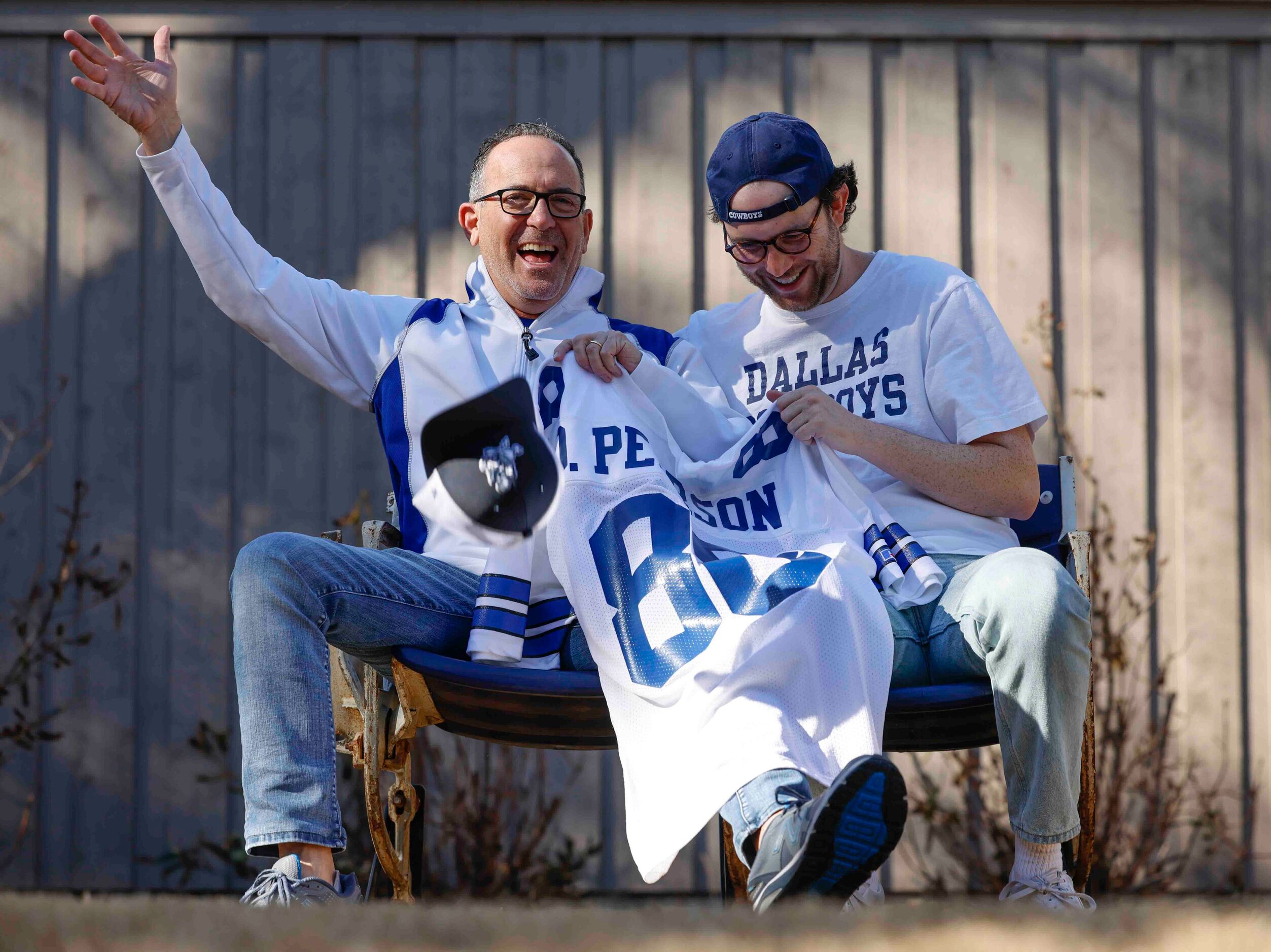 Cowboys fans Marc, left and his son Miles Andres cheer in between a portrait session at...