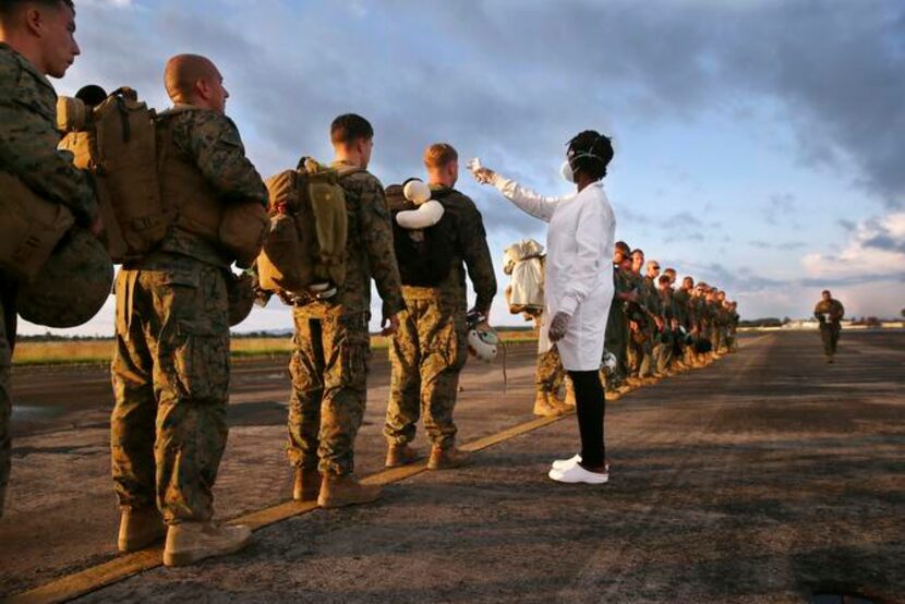 
The hazards of military service: A health worker takes the temperature of U.S. Marines...