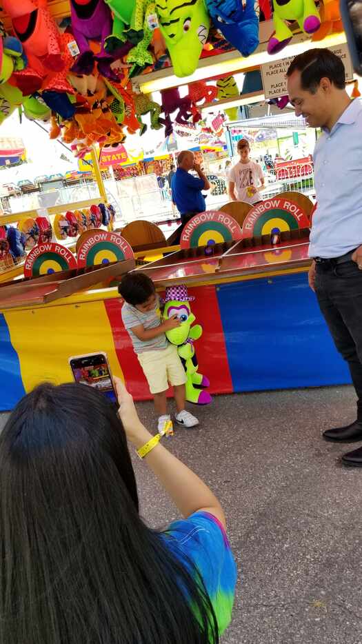 Cristián Castro, 4, won a plush neon green duck by rolling four balls each into a different...