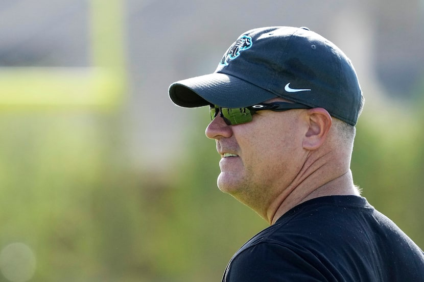 Head coach Clint Surratt watches players run drills during the first day of football...