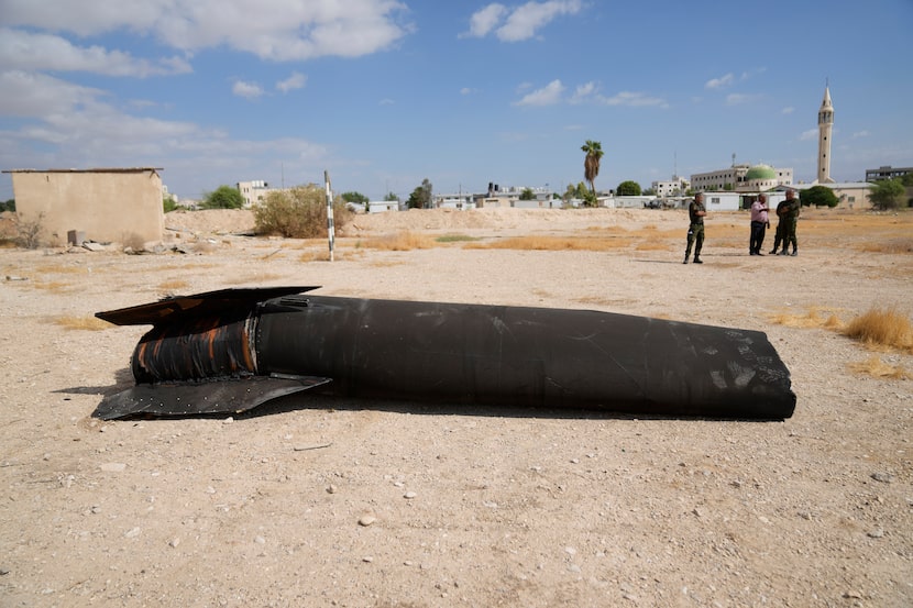 Officers from the Palestinian National forces inspect part of a rocket, launched during...