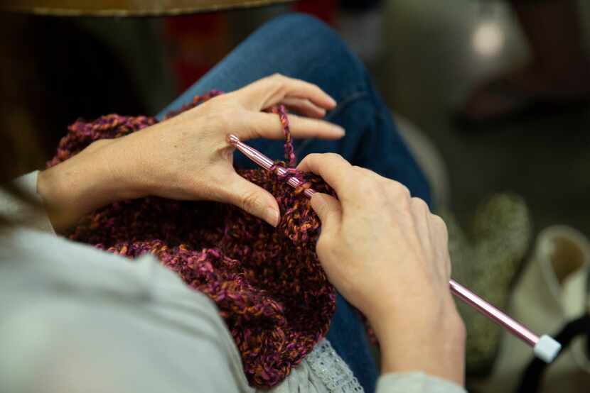 At Spreading the Warmth's monthly Knit Night, a participant works on a scarf. 