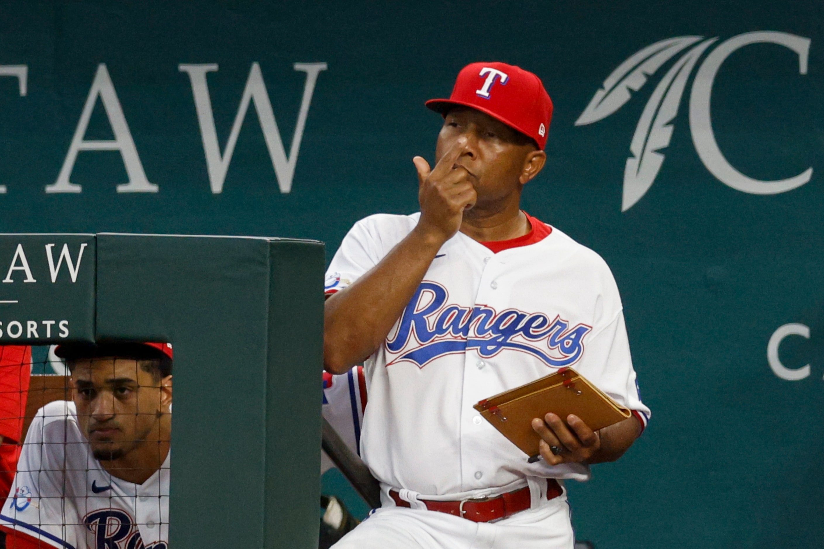 Texas Rangers interim manager Tony Beasley (27) flashes a sign during the first inning of a...