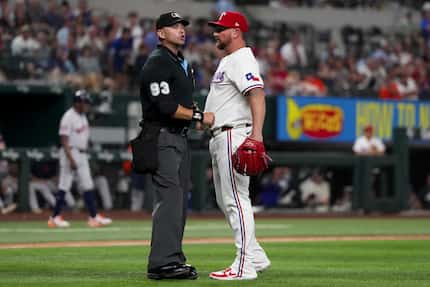 Texas Rangers relief pitcher Kirby Yates, right, talks to home plate umpire umpire Will...