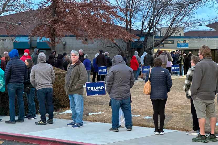 People wait in line to enter a caucus site at Katherine Dunn Elementary School in Sparks,...