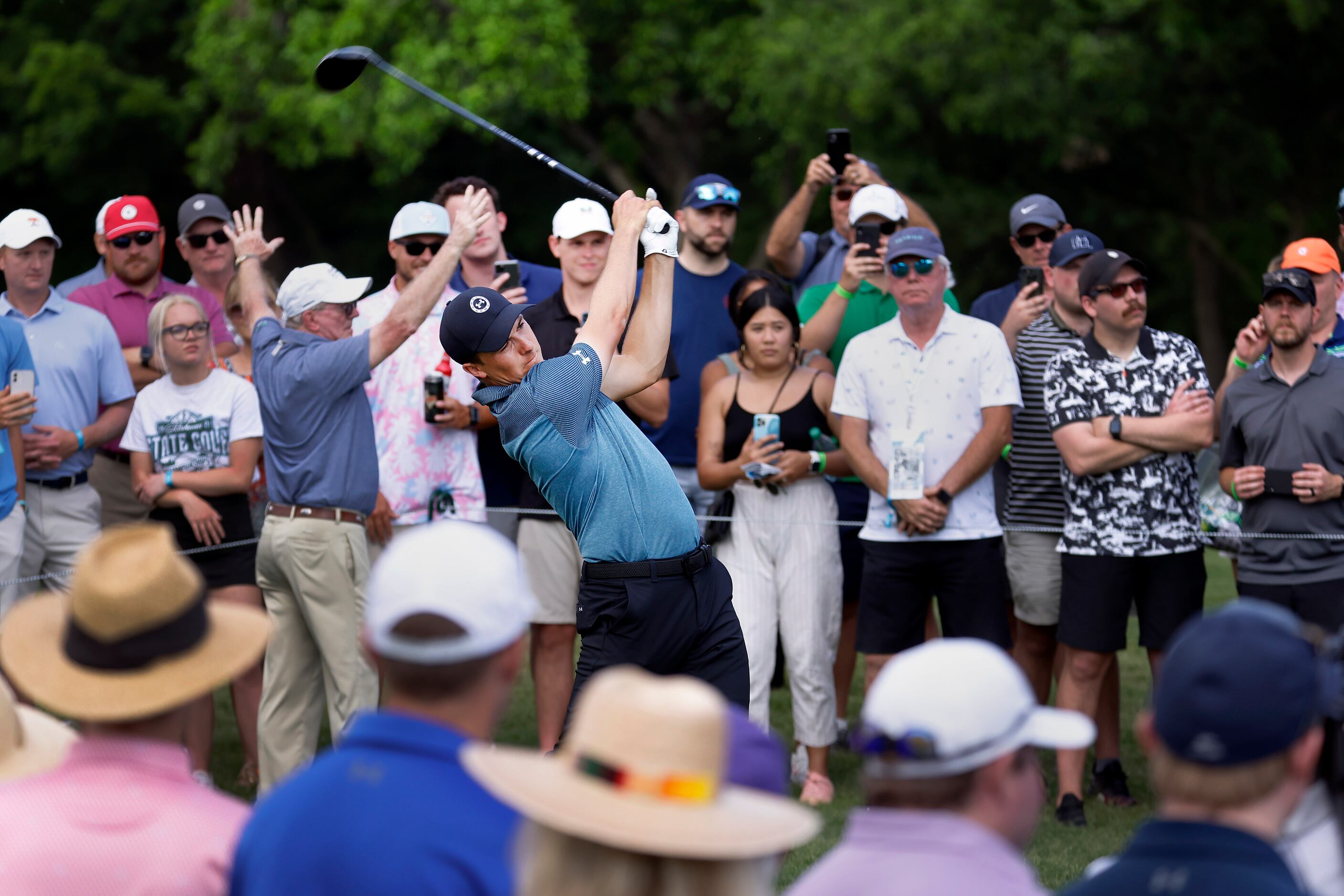 Fans watch as professional golfer Jordan Spieth tees off on No. 14 during round three of the...