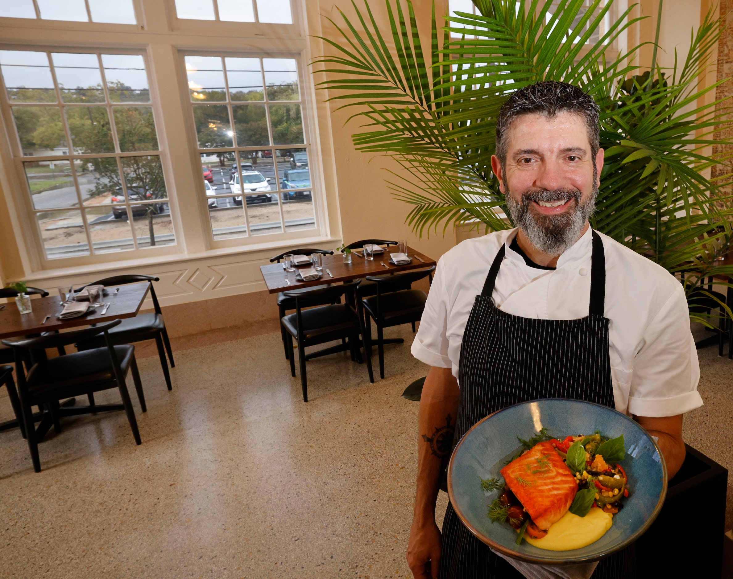 Executive Chef David Bull holds a salmon dish at The Crazy Water Hotel's new restaurant...